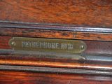 a brass plate on the front of a wooden cabinet