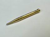 un stylo doré posé sur une table blanche