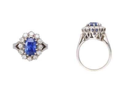 a close up of a ring with a sapphire and a diamond