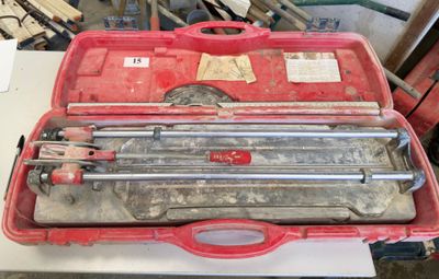 une mallette rouge contenant des outils, posée sur une table