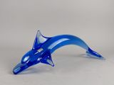 un dauphin en verre bleu posé sur une table