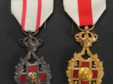 two medals with red and white ribbons on a black surface