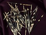 a close up of a pile of toothpicks on a purple cloth
