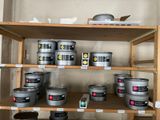 many tins of paint on a shelf in a room