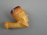 a small pipe with a man ' s head on it