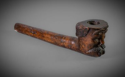 an old pipe with a wooden handle on a gray background