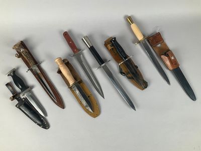 several different types of knives are lined up on a white surface