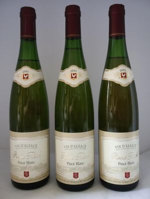 trois bouteilles de vin posées sur une table, l'une à côté de l'autre