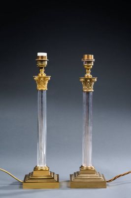 a pair of brass and glass table lamps with candles on them