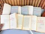 several old books are stacked on top of each other in a wicker basket