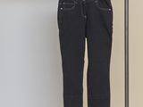 jeans hanging on a clothes rack in front of a white wall