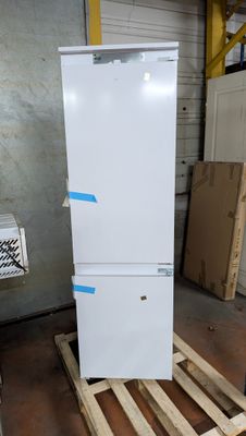 a white refrigerator sitting on a pallet in a warehouse