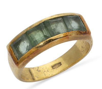 a close up of a gold ring with green stones on it
