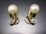 une paire de boucles d'oreilles en perles et diamants sur fond noir