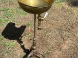 a birdbath that is sitting on a stand in the grass