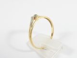 a close up of a gold ring with a diamond on top