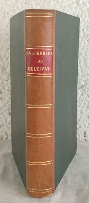 un vieux livre posé sur une table à côté d'un mur