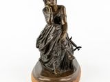 a bronze statue of a woman sitting on a bench
