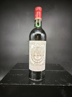 une vieille bouteille de vin posée sur une boîte noire