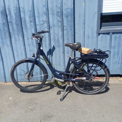 un vélo garé devant un immeuble bleu
