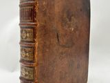 an old book sitting on top of a white table next to a white background