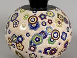 un vase orné d'un motif coloré, posé sur une table