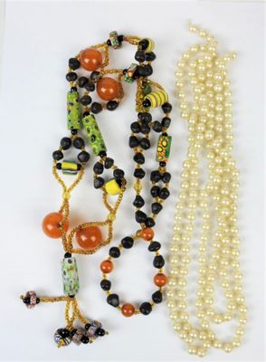 two necklaces with beads and beads on a white surface