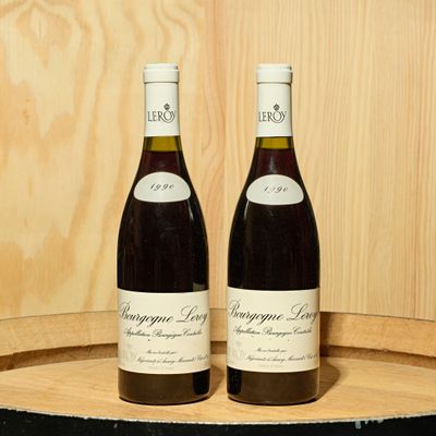deux bouteilles de vin posées l'une à côté de l'autre sur un tonneau