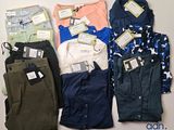 several pairs of pants and shirts are laid out on a table