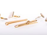 three pairs of gold and white cufflinks and a pair of earrings
