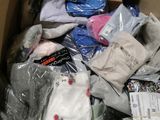 une boîte en carton remplie de vêtements, posée par terre