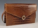 an image of a brown crocodile skin purse with a gold clasp