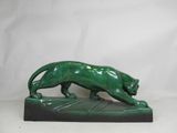 a green statue of a lion on a black base