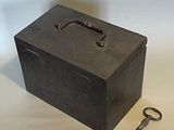 a black box with a key and a keychain on a table