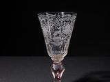 a wine glass sitting on a table with a black background
