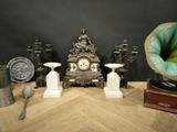 a table with a clock, vases, and other items on it
