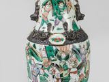 a vase with a painting on it sitting on a table