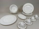 beaucoup d'assiettes et de bols blancs sur la table