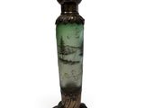 a green vase with a painting on it sitting on a stand