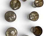 six silver cups are arranged in a circle on a white surface