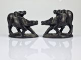 two figurines of elephants on a white surface