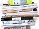 many rolls of paper and pens on a white surface