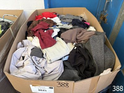 a cardboard box full of clothes in a room