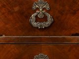 a wooden chest of drawers with a metal handle on it