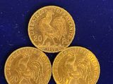 three gold sovereigns on a blue surface