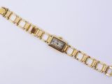 a close up of a gold wrist watch on a white surface