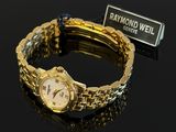 an image of a gold wrist watch sitting on top of a black table