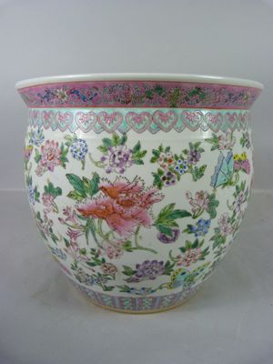 un vase blanc orné d'un motif rose et bleu