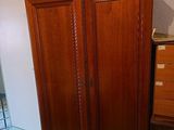 an image of a bedroom with a bed, dresser, and armoire