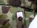 a close up of a camouflage bag with a button on it